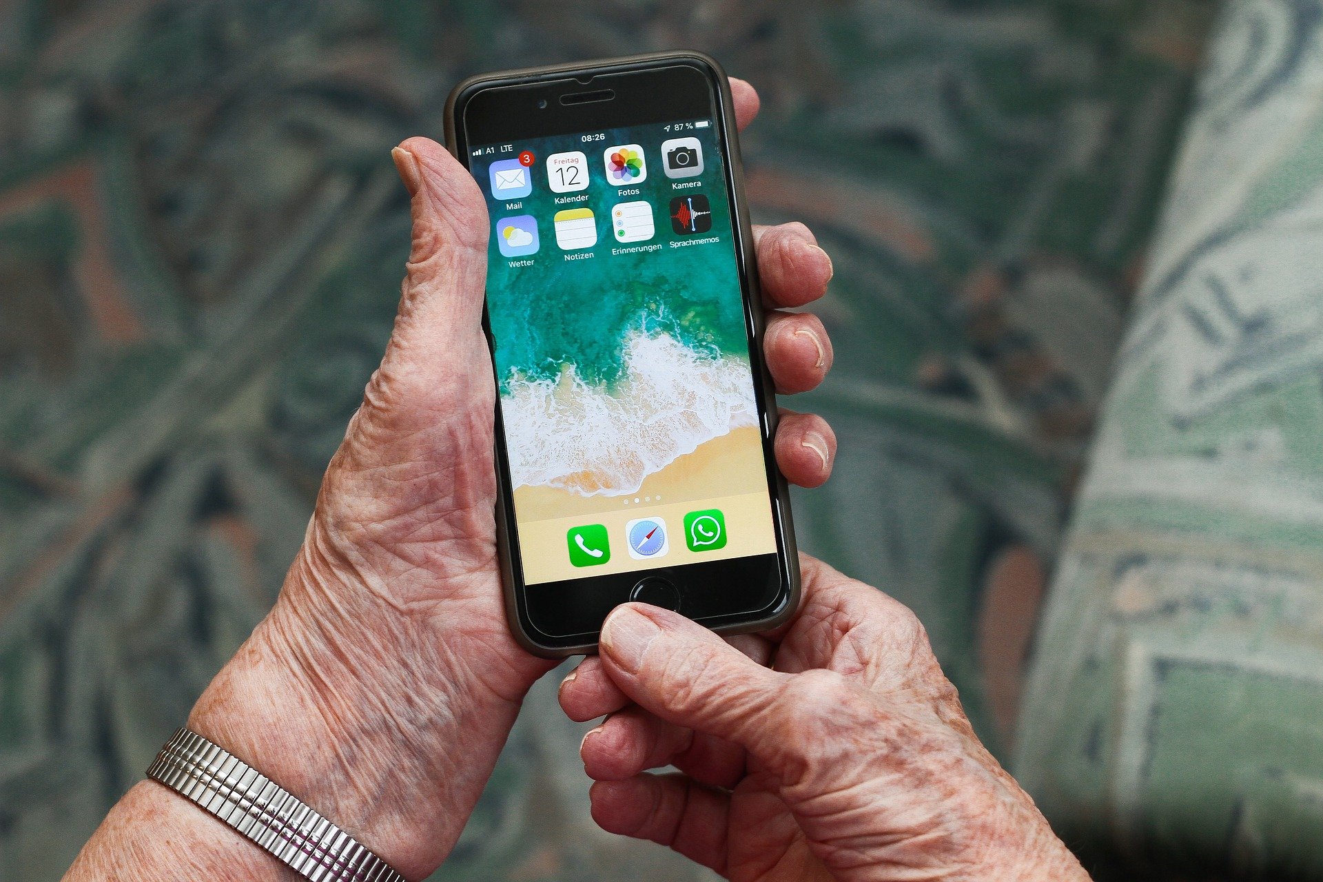 Seniorin hält eine Smartphone in der Hand