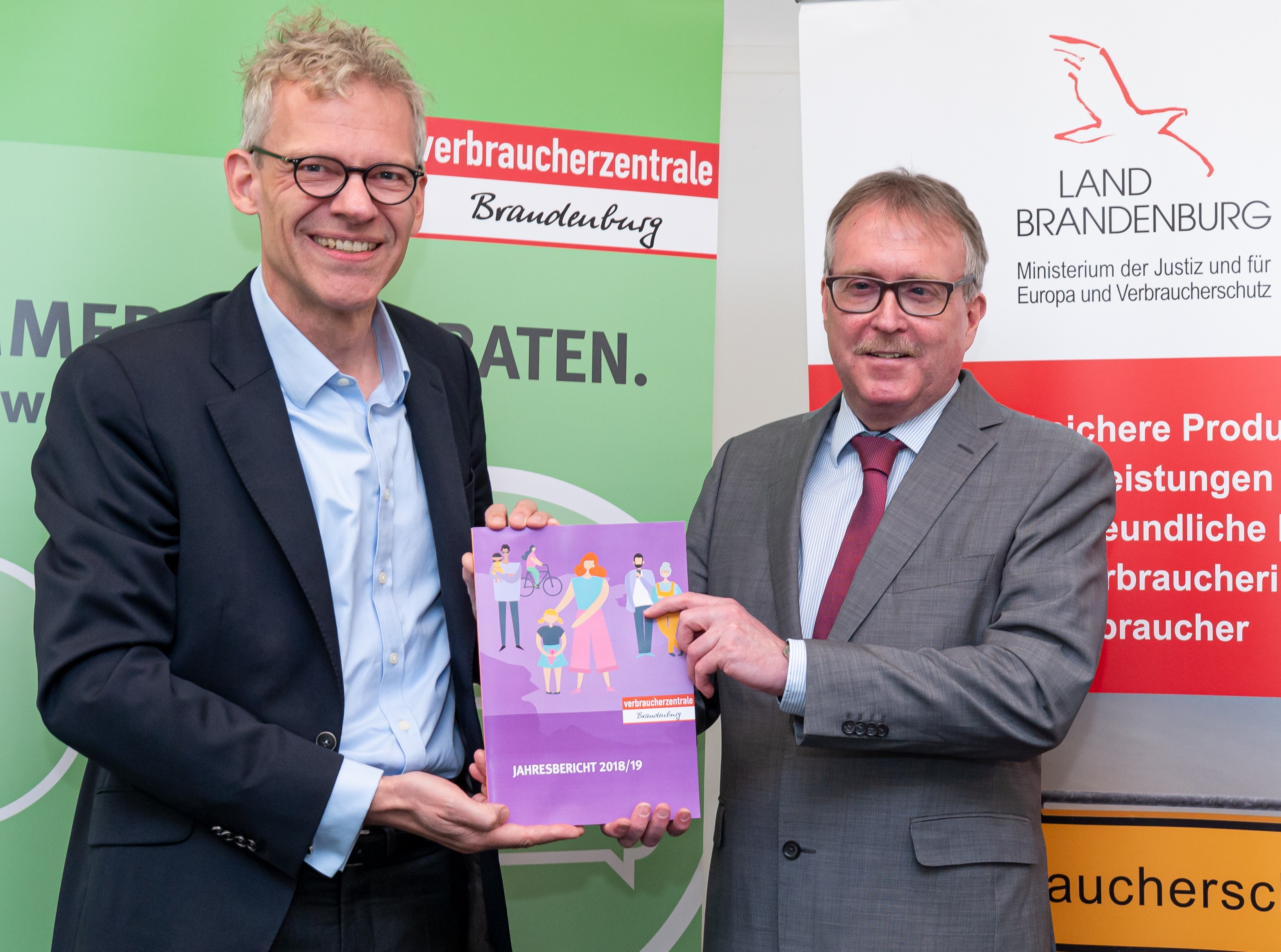 VZB-Geschäftsführer Dr. Christian A. Rumpke (links) übergibt Verbraucherschutzminister Stefan Ludwig den Jahresbericht 2018/19. (c) Karla Fritze / VZB