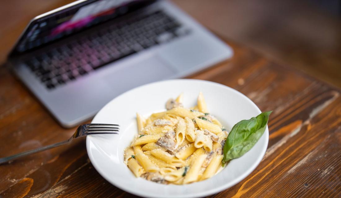 Teller mit Nudeln vor einem Laptop auf einem Schreibtisch (c) engin akyurt / Unsplash