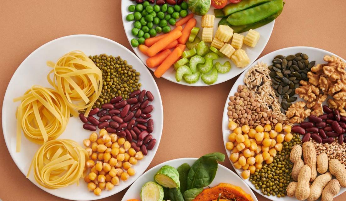 Mehrere Teller mit Nudeln, Bohnen, Kernen, Nüssen und Gemüse. (c) Vanessa Loring / Pexels