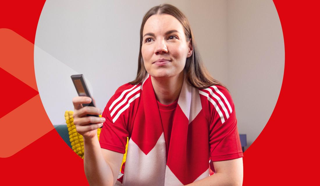 junge Frau lächelt und hält Fernbedienung in der Hand