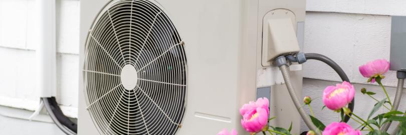 Eine Wärmepumpe hängt außen an einer Hauswand.