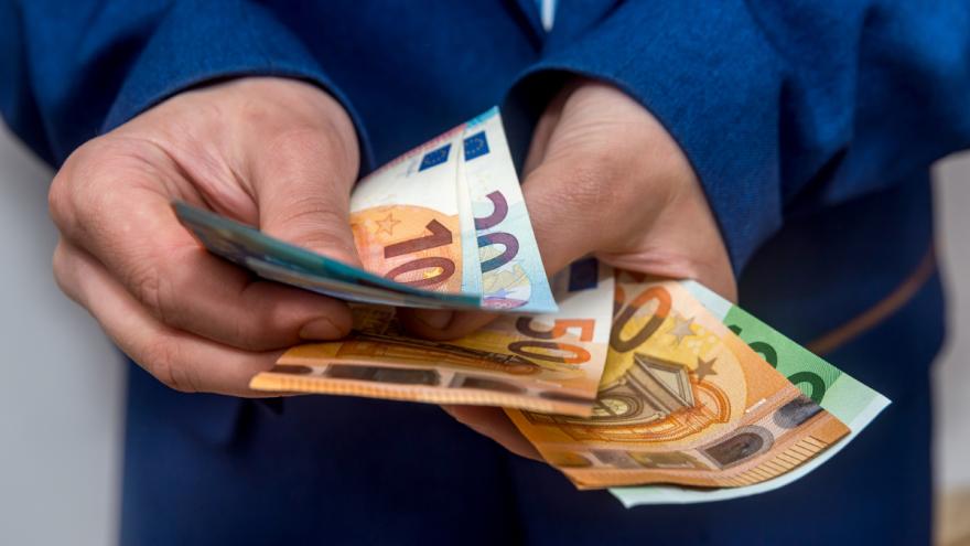 Ein Mann zählt Euro-Geldscheine