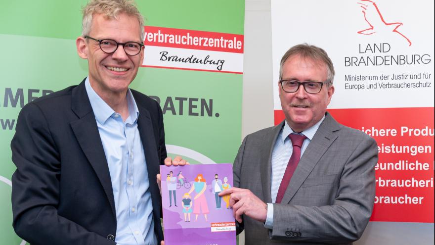 VZB-Geschäftsführer Dr. Christian A. Rumpke (links) übergibt Verbraucherschutzminister Stefan Ludwig den Jahresbericht 2018/19.