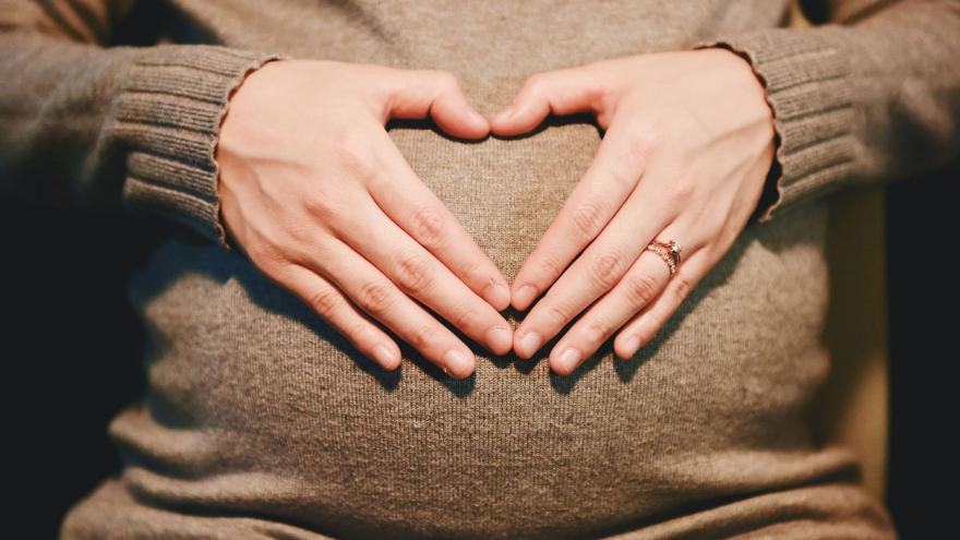 Schwangere Frau hält ihre Hände auf dem Bauch und formt ein Herz Bildquelle: StockSnap / Pixabay