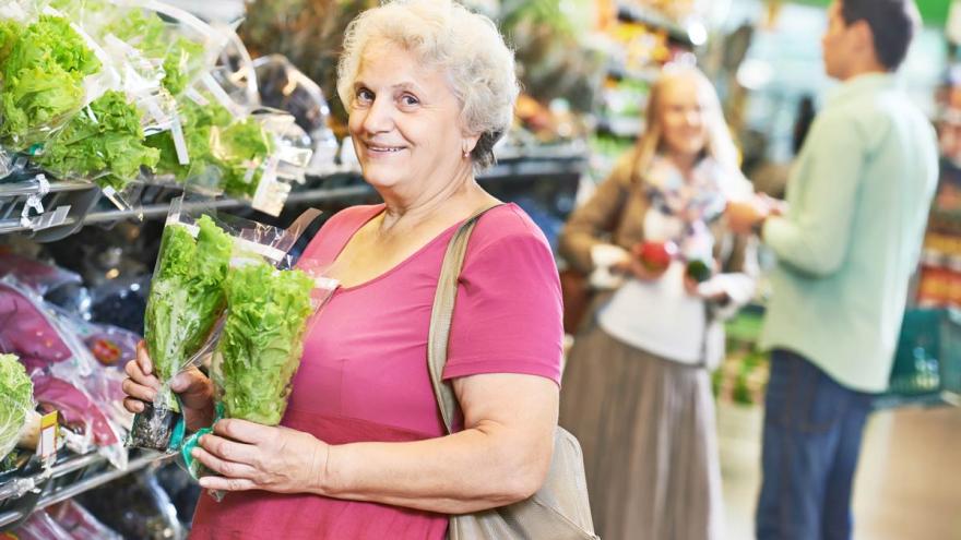 Seniorin am Supermarktregal mit Salatpflanzen in der Hand. (c) Kadmy / AdobeStock
