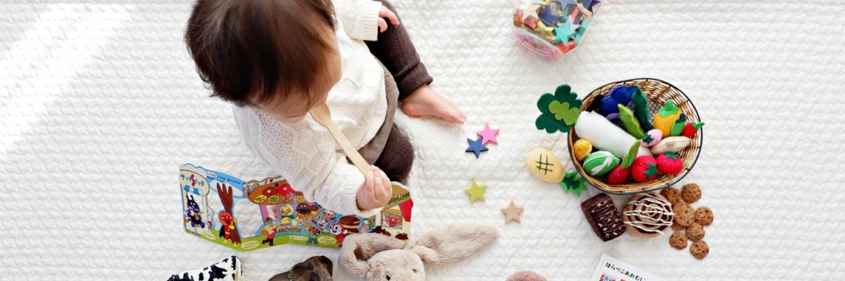 Kind sitzt inmitten von Spielzeug