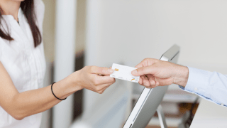 Mann überreicht in Arztpraxis seine Versicherungskarte