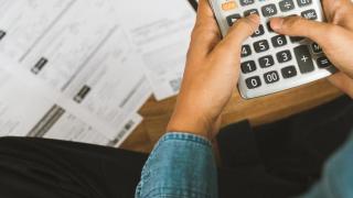 Hände an Taschenrechner über Verträgen