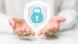 Geöffnete Hände halten ein Schloss. Es geht um Datenschutz